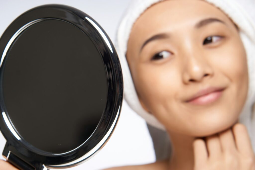 pretty woman looking in the mirror healthy skin rejuvenation spa treatments