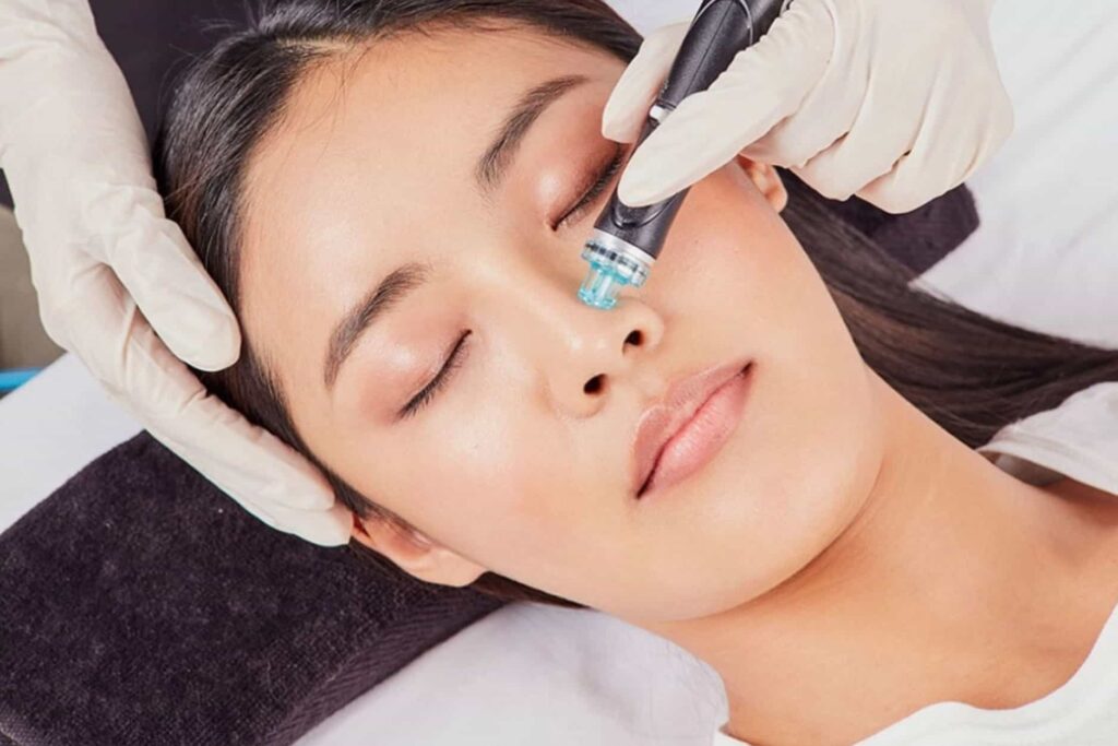 Licensed Aesthetician Performing Hydrafacial Procedure On Woman